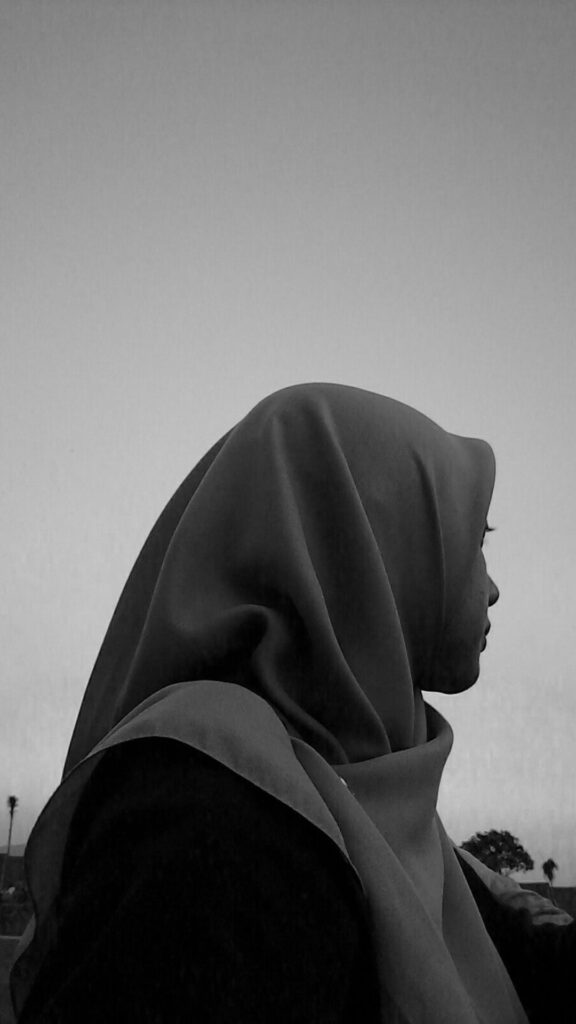 Backpose cewek manis pakai Hijab dengan latar langit hitam putih