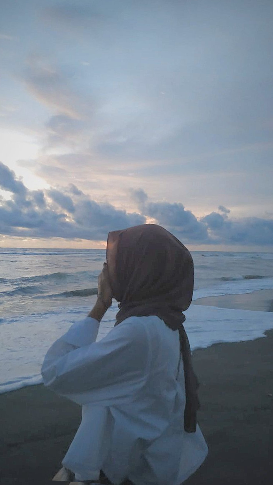 pp aesthetic hijab di pnatai dengan deburan ombak titop wajah serong di pantai pas senja
